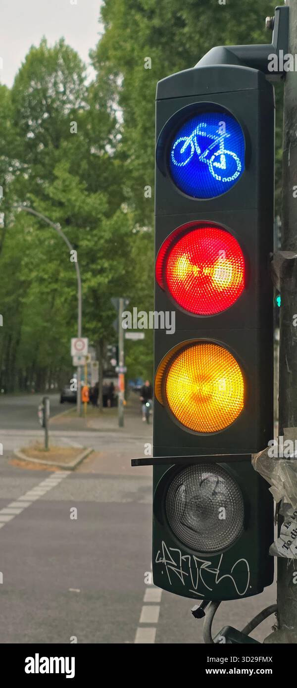 Belin, Germany - May 19, 2025: Bicycle traffic signal displays blue, red, and yellow lights in a city environment. - Smartphone Captured Stock Image