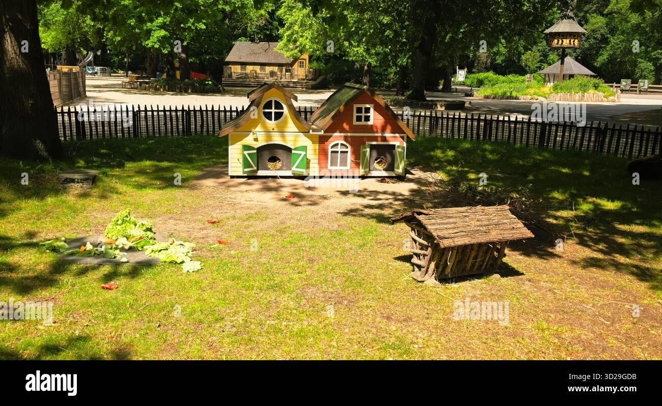 Berlin, Germany - May 22, 2025: Colorful animal houses are situated in a sunny park surrounded by green grass and trees. - Smartphone Captured Stock Image