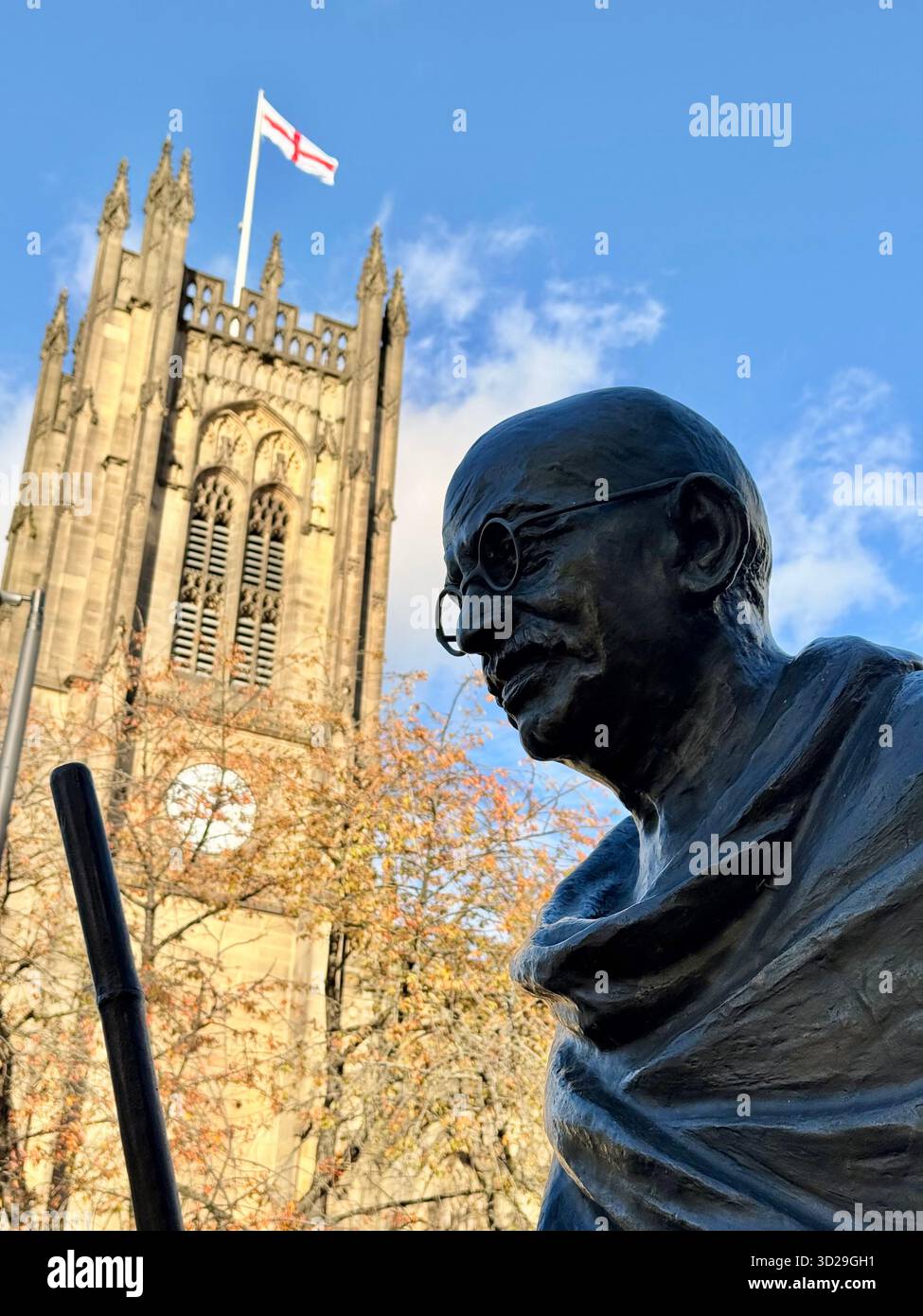 Close up of Statue of Mahatma Gandhi with Manchester Cathedral in background in Manchester City centre - Smartphone Captured Stock Image