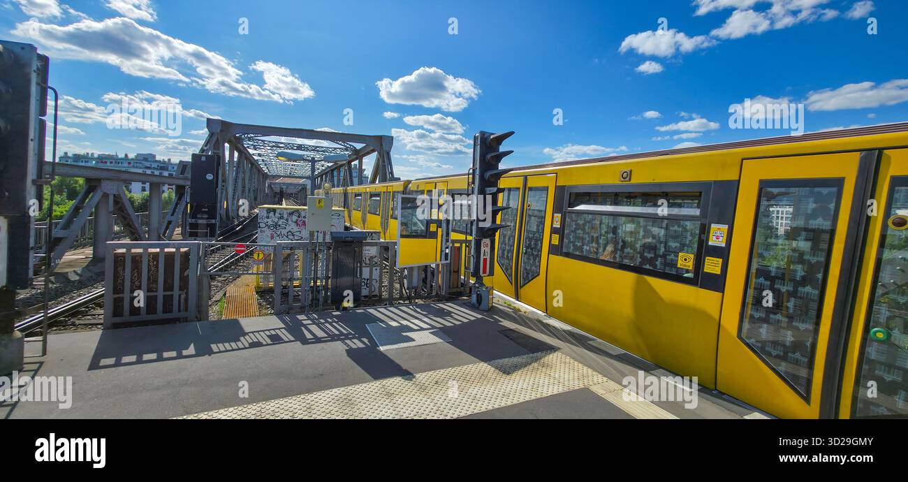 Berlin, Germany - July 04, 2025: Yellow train is stationed at urban platform under bright blue sky. - Smartphone Captured Stock Image