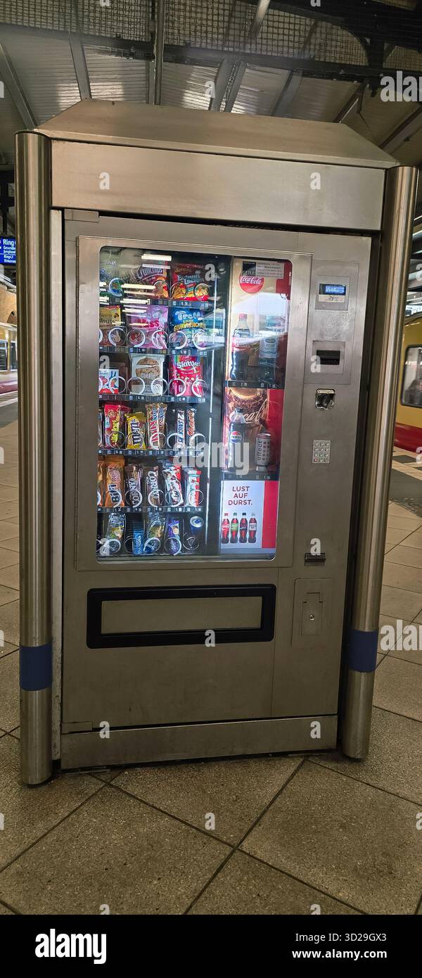 Berlin, Germany - June 05, 2025: Vending machine displays various snacks and drinks at busy train station. - Smartphone Captured Stock Image