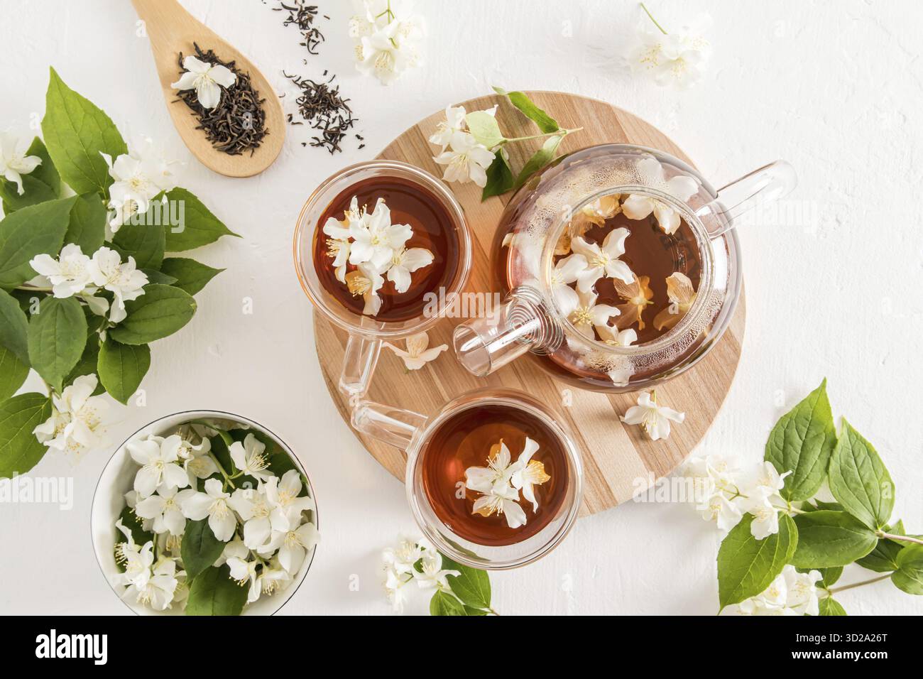 Beautiful tea composition with a modern teapot and cups with tea fragrant jasmine. top view. white textured background Stock Photo