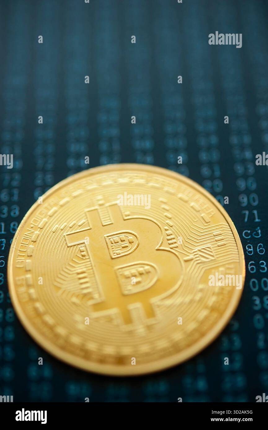 Golden Bitcoin coin on binary code background symbolizing digital cryptocurrency and blockchain technology Stock Photo