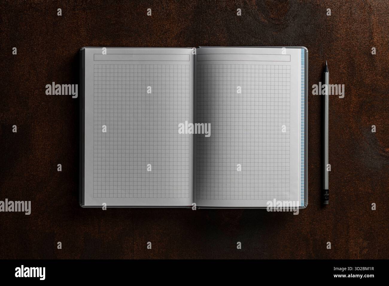 Open notebook with checkered sheets and pencil on wooden texture background, close up, top view, copy space Stock Photo