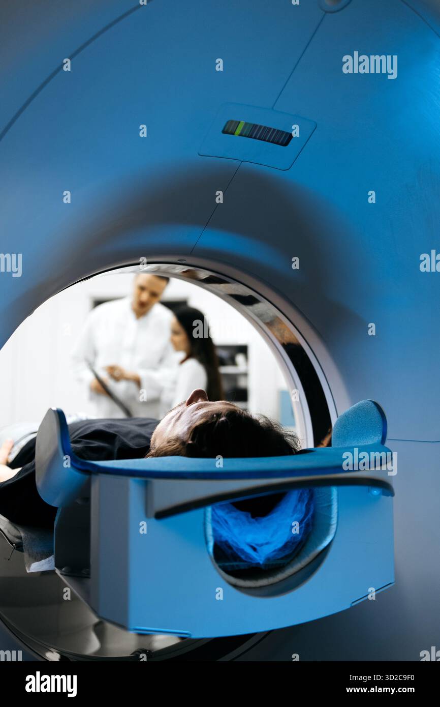 Interior view of CT scanner with patient on examination table, medical ...