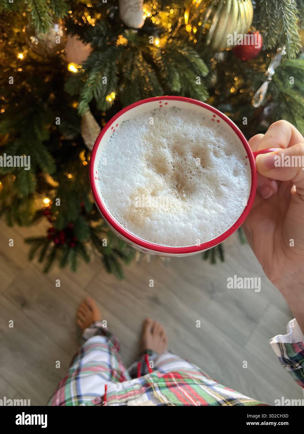 A cozy New Year's interior with a decorated Christmas tree, an armchair, a blanket, and a cup of coffee by the window - Smartphone Captured Stock Image