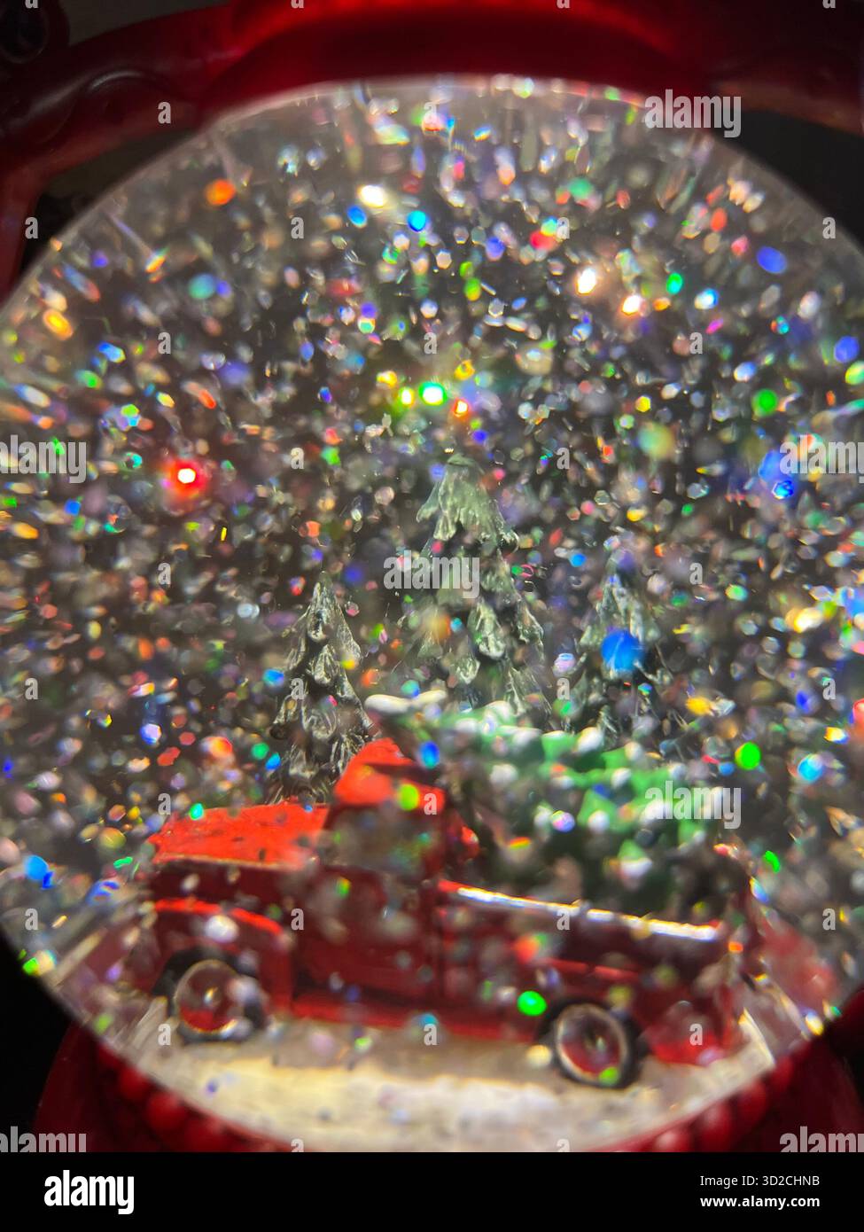 Snow globe with red car and glitter reflections, close-up - Smartphone Captured Stock Image