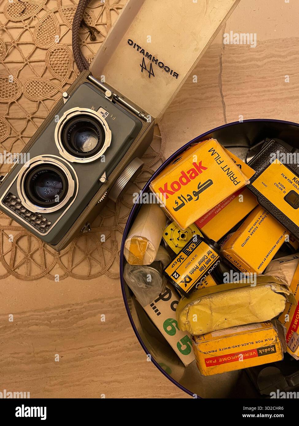 Vintage TLR film camera Ricohmatic 44 with old Kodak films from Arabic country laid out on table - Smartphone Captured Stock Image