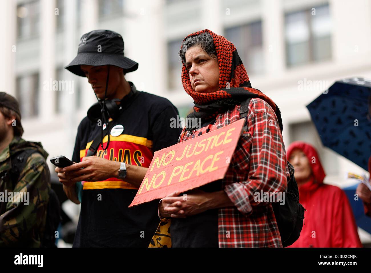 Protesters look on during speeches at the National Day of Action ...