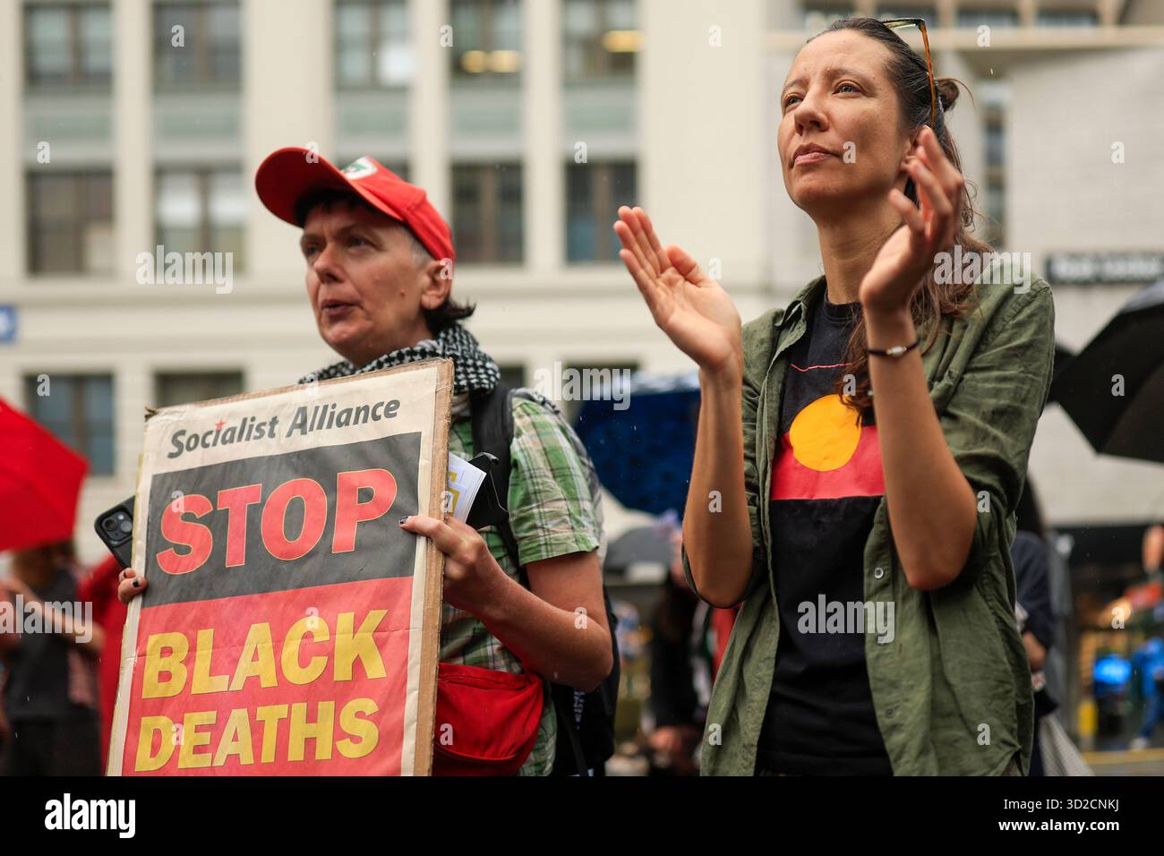 Protesters look on during speeches at the National Day of Action ...