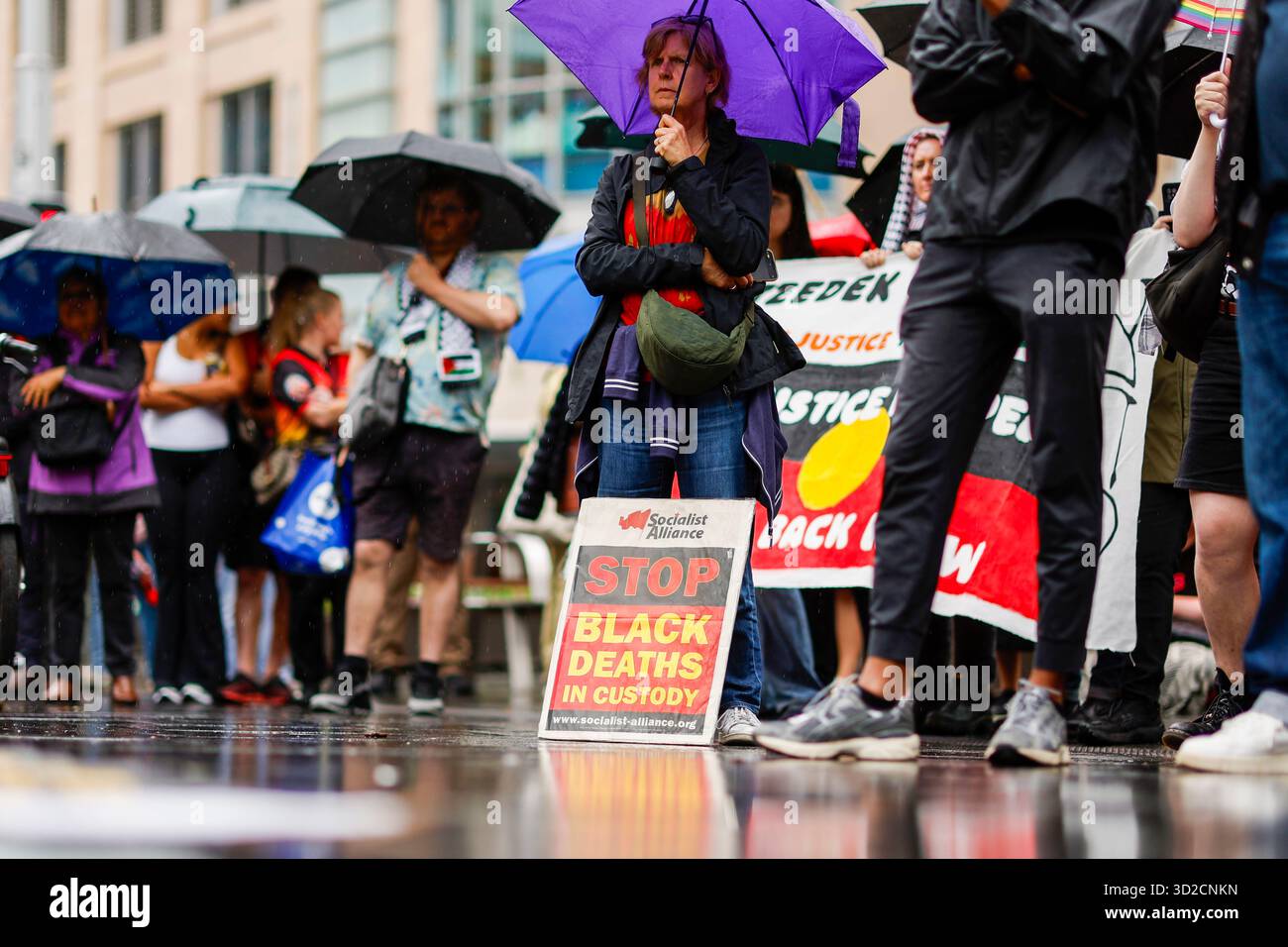 Protesters look on during speeches at the National Day of Action ...