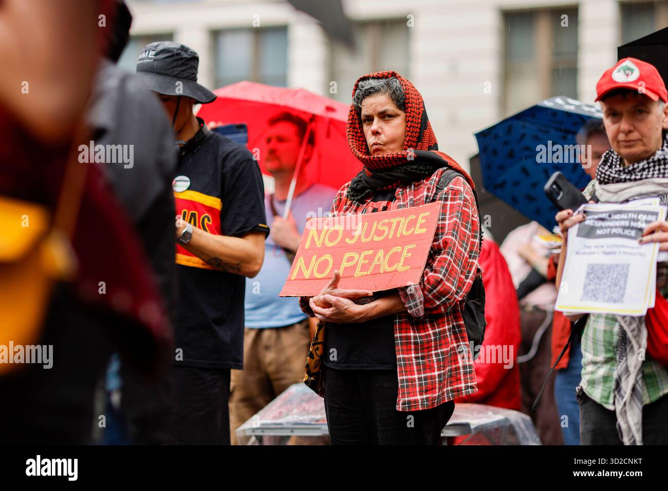 Protesters look on during speeches at the National Day of Action ...