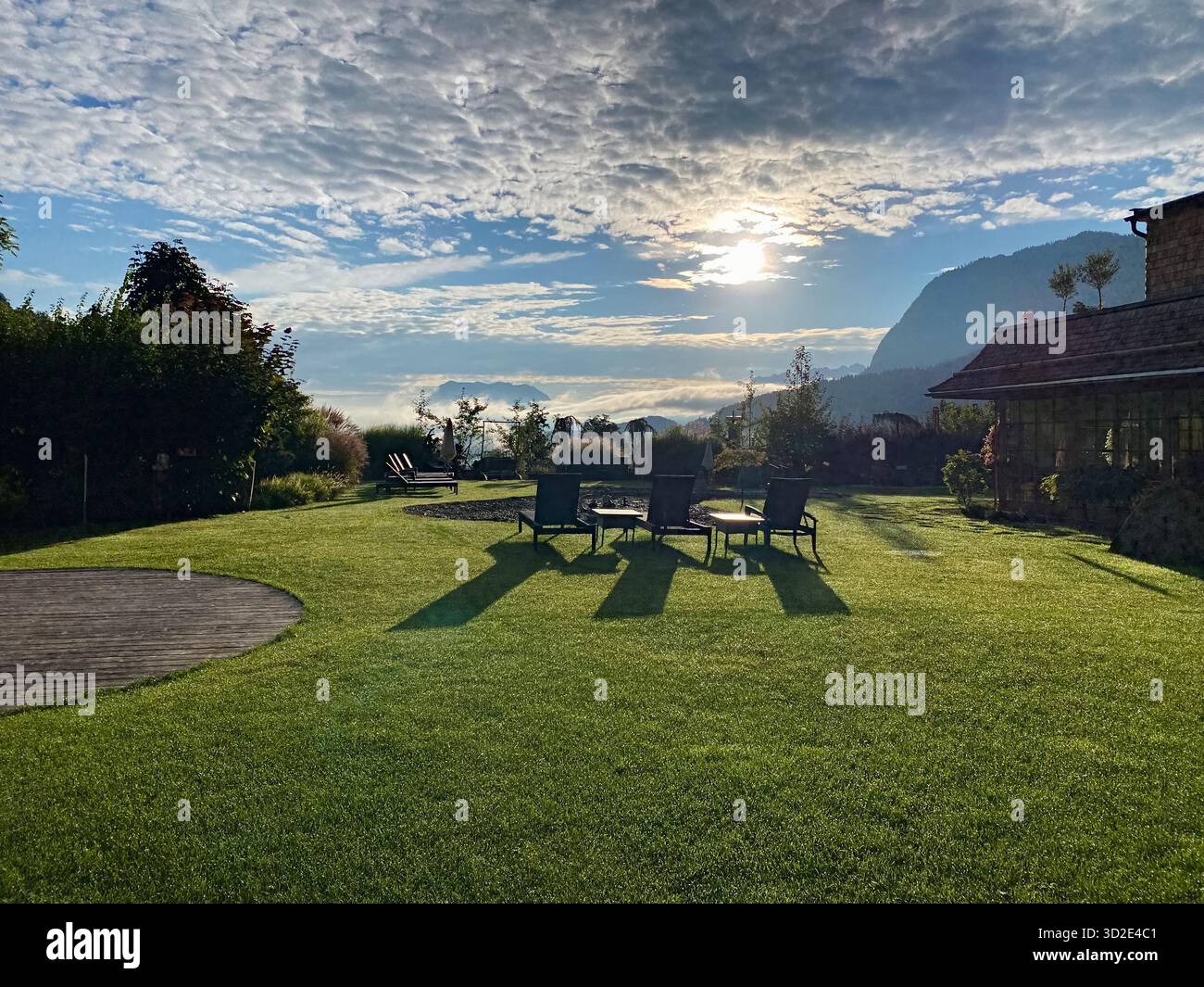 Relaxing lounge chairs on a green lawn with scenic Alps view in Austria. - Smartphone Captured Stock Image