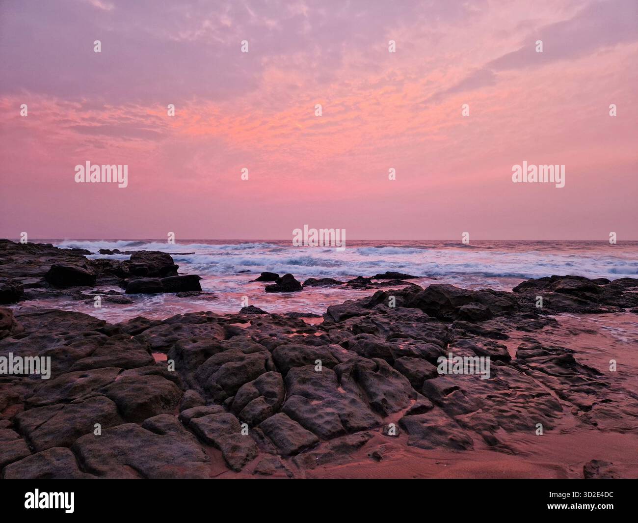 Vibrant Pink Sunset over Thompson Bay Rocky Shoreline in Ballito, South Africa. - Smartphone Captured Stock Image