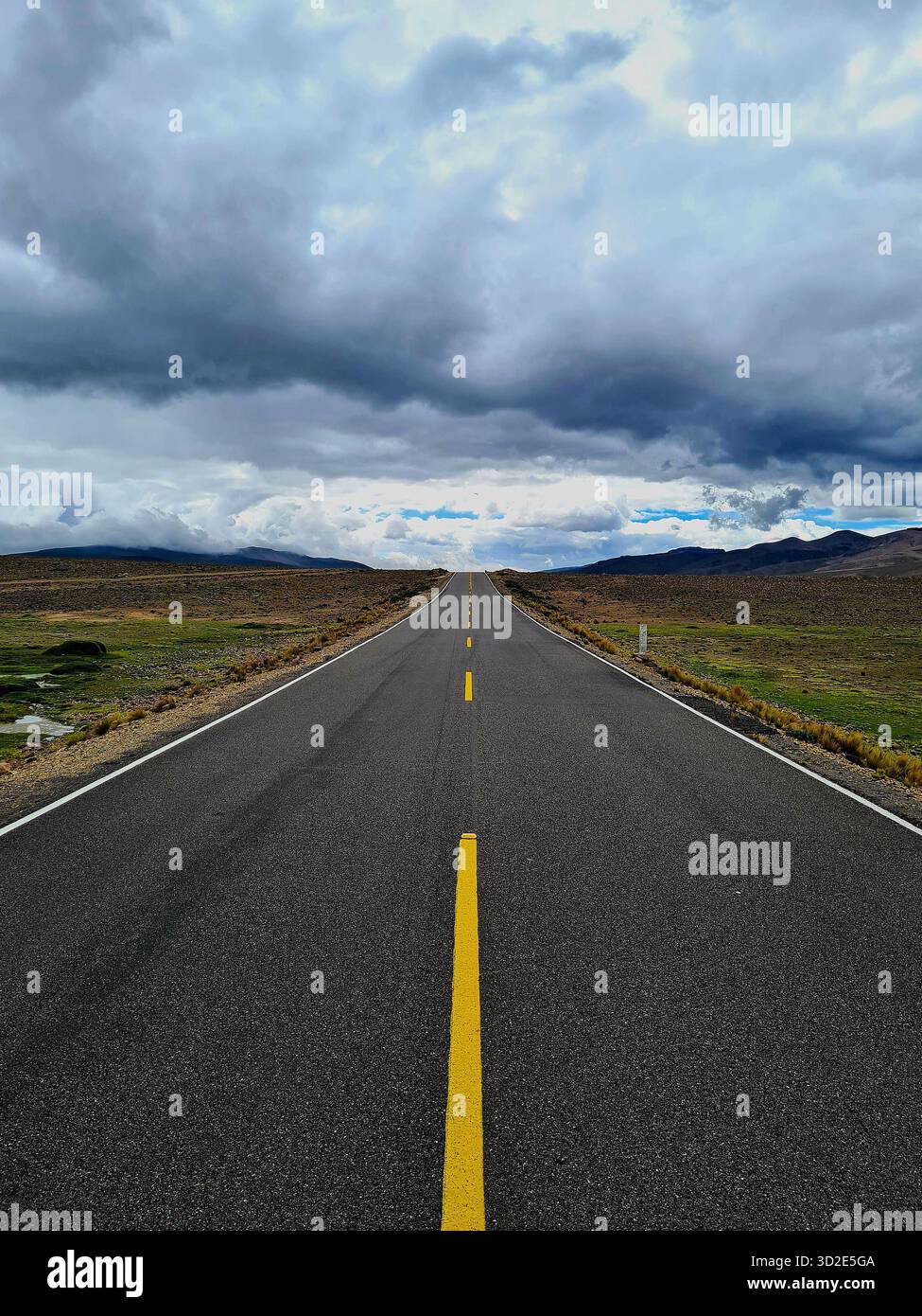 Endless straight road through the Andes mountains under a dramatic sky, Peru. - Smartphone Captured Stock Image