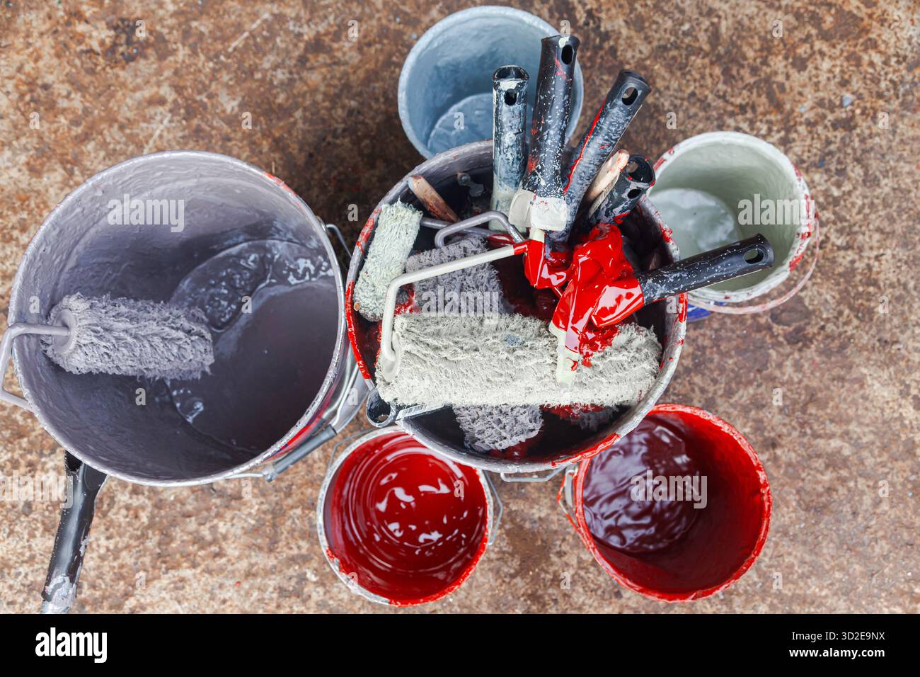 Empty paint buckets containing used rollers and brushes Stock Photo