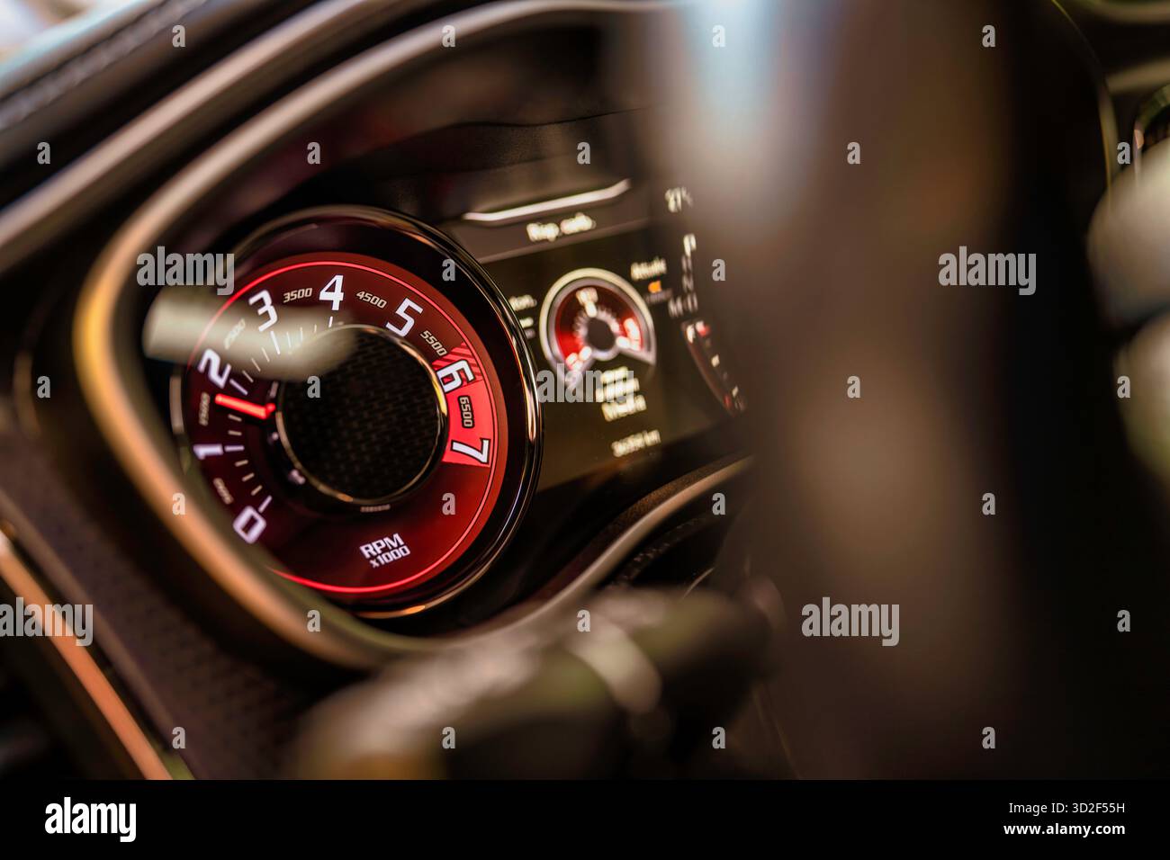 Car dashboard with a glowing red tachometer needle and clear rpm ...