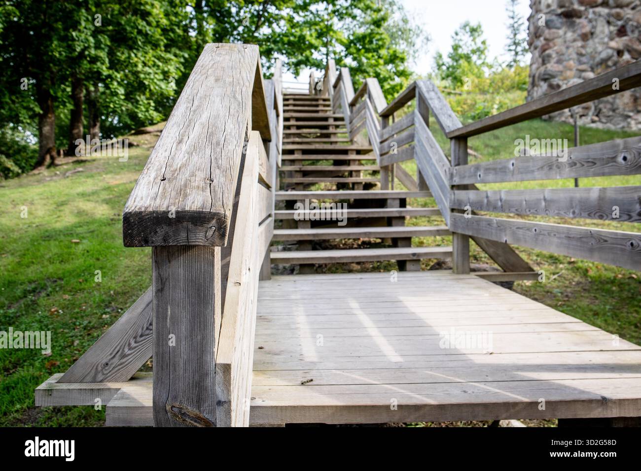 Rustic wooden staircase with railings leading uphill in a natural park ...