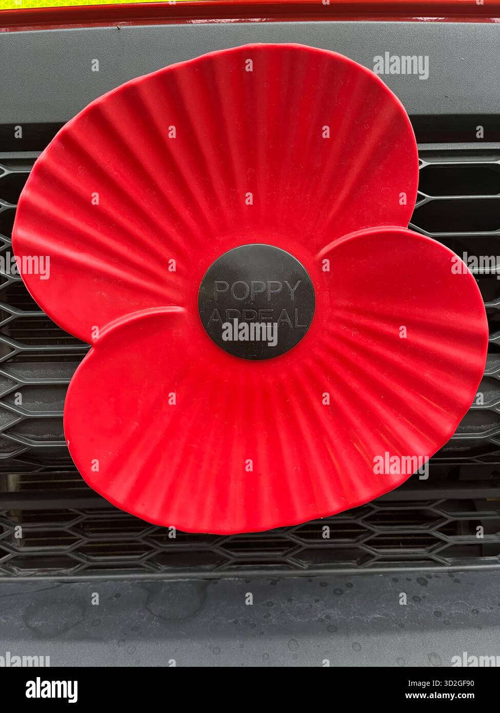 Plastic remembrance poppy on car bumper of a fire engine - Smartphone Captured Stock Image