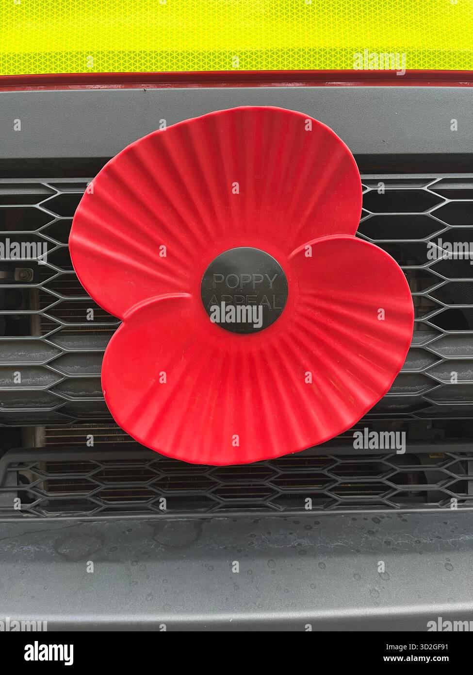 Plastic remembrance poppy on car bumper of a fire engine - Smartphone Captured Stock Image