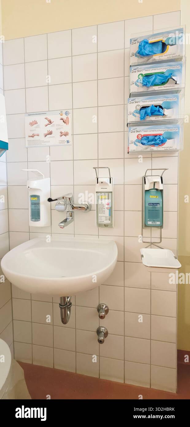 Berlin, Germany - June 16, 2025: Medical washbasin features hygiene products and gloves in a clean healthcare environment. - Smartphone Captured Stock Image