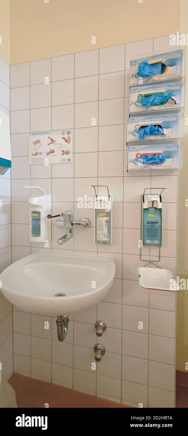 Berlin, Germany - June 16, 2025: Medical wash station features hand sanitizer, gloves, and hygiene instructions in healthcare setting. - Smartphone Captured Stock Image