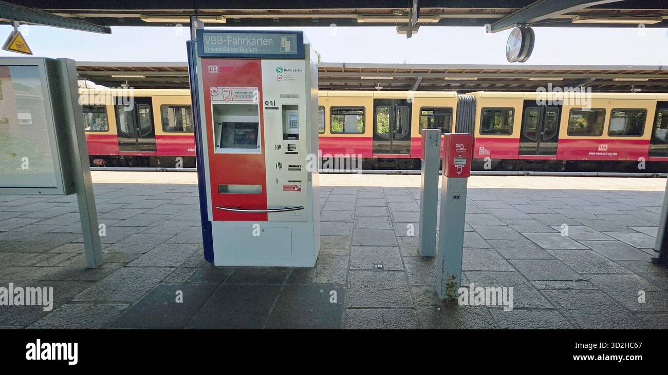 Berlin, Germany - June 13, 2025: Ticket vending machine at train station with train visible in background and bright daylight. - Smartphone Captured Stock Image