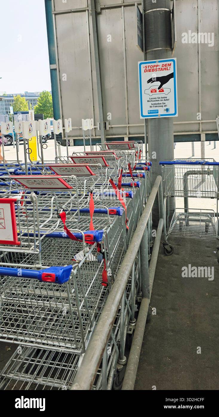 Berlin, Germany - June 21, 2025: Shopping carts are neatly arranged in a supermarket with signage visible. - Smartphone Captured Stock Image