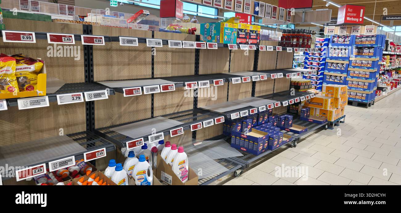 Berlin, Germany - June 28, 2025: Grocery store shelves show empty spaces with various products in the background. - Smartphone Captured Stock Image