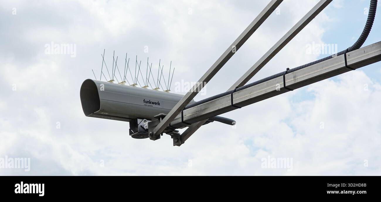 Berlin, Germany - July 03, 2025: . Surveillance camera is mounted on pole with antennas against cloudy sky - Smartphone Captured Stock Image