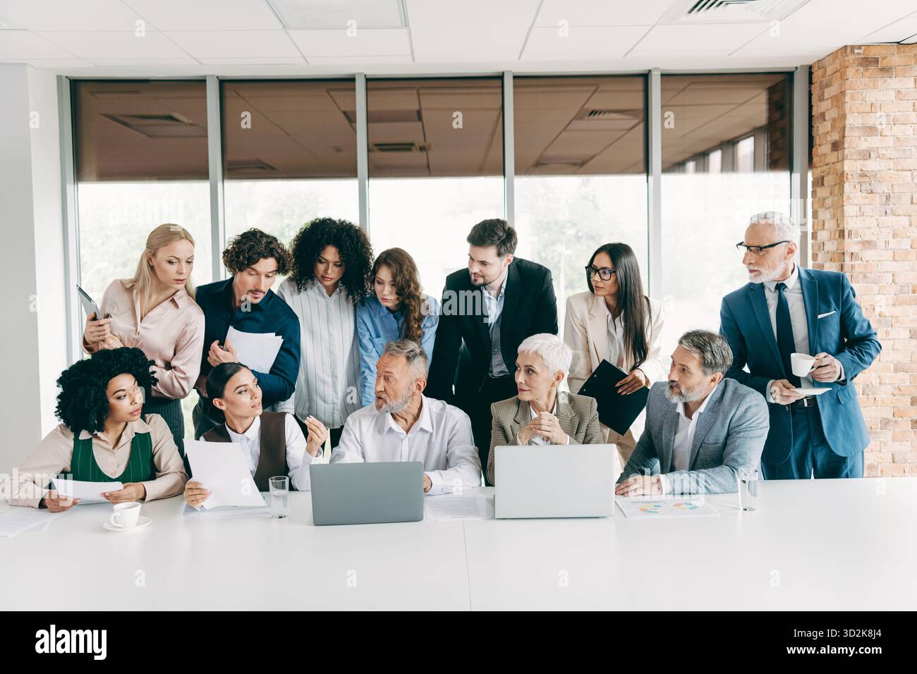 Diverse colleagues engage in an office meeting, collaborating around a ...