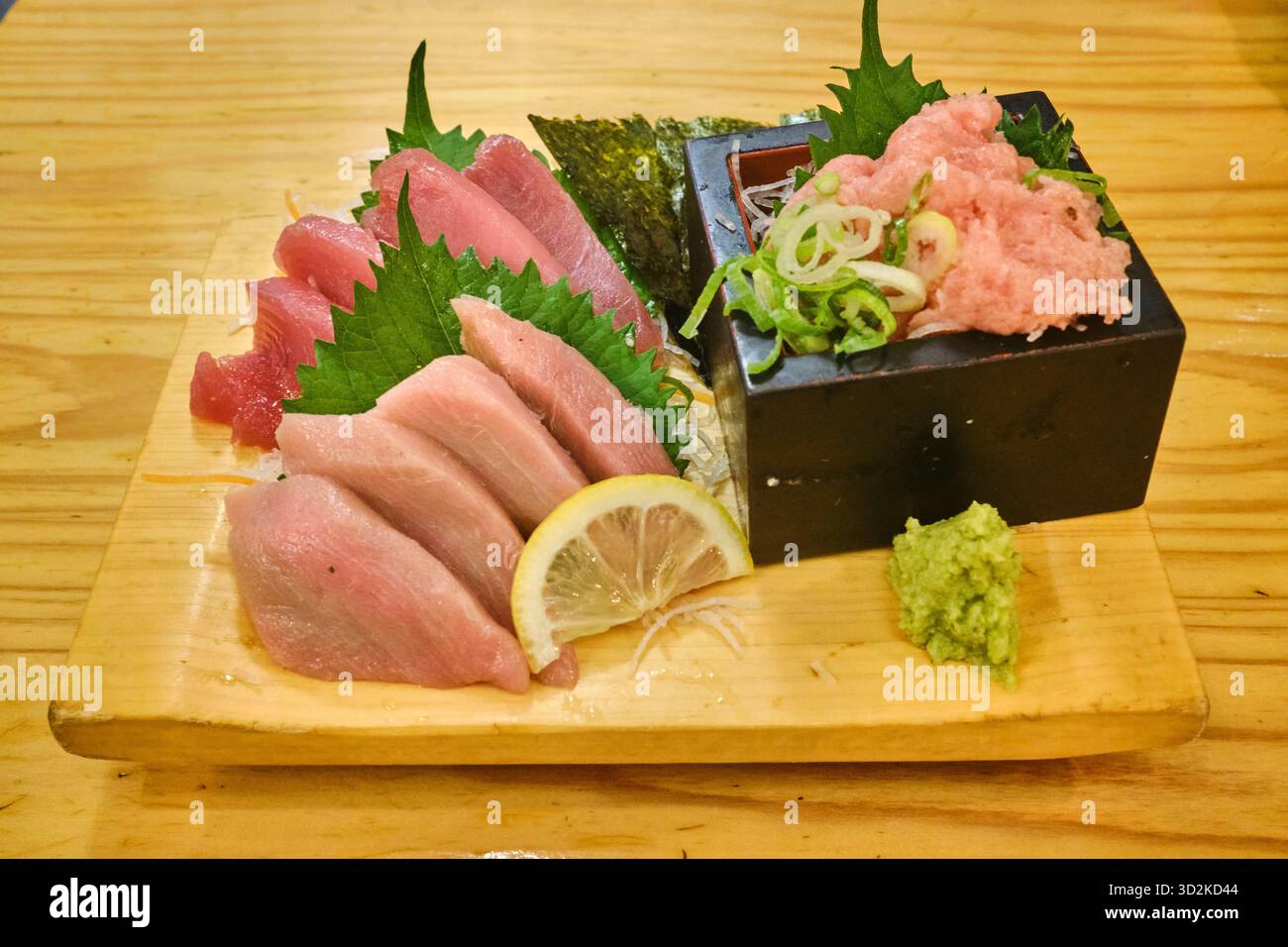 A variety of fresh tuna sashimi beautifully arranged on a traditional wooden geta plate Stock Photo