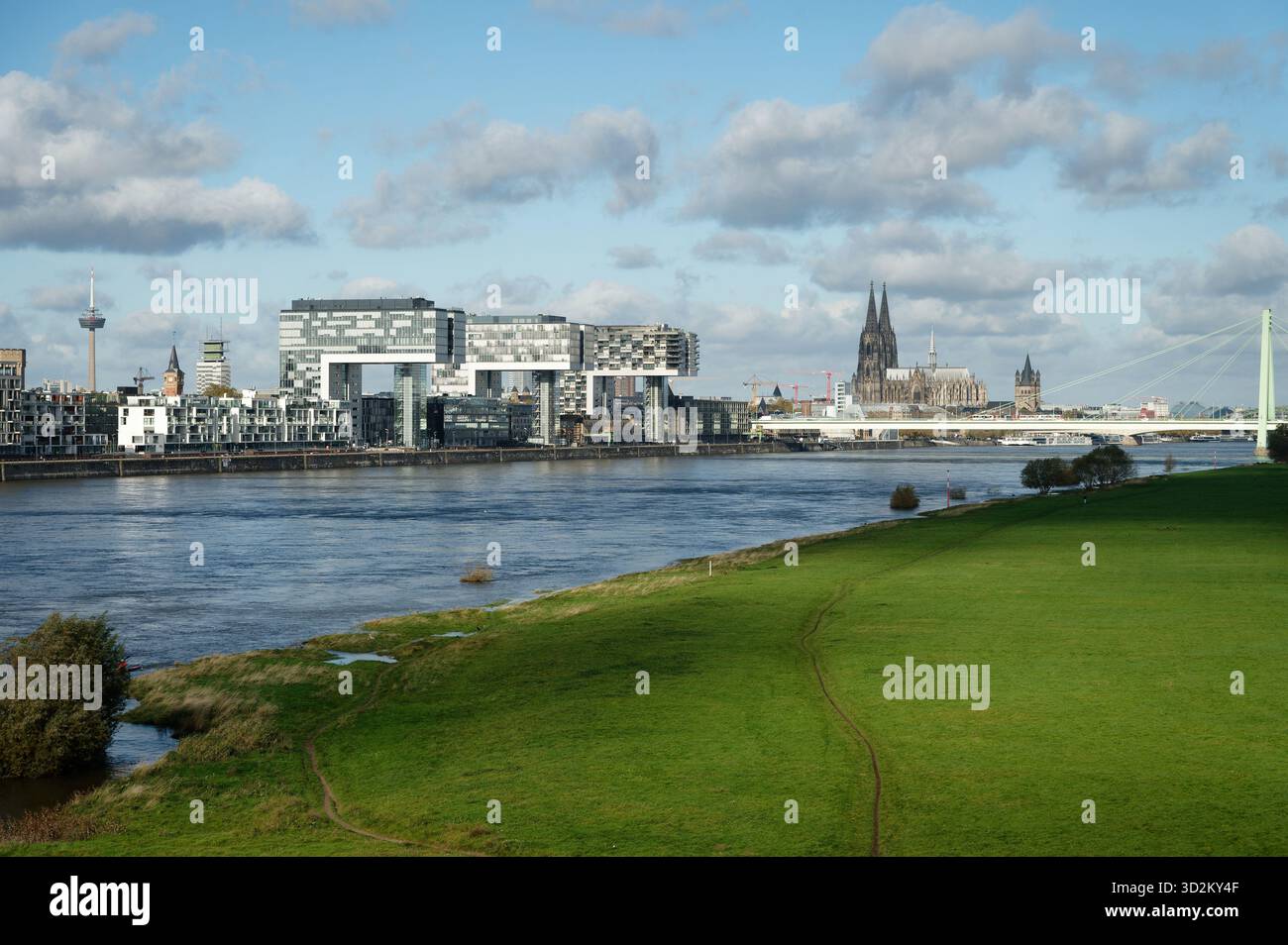 Iconic Panoramic View Of Cologne At The End Of October. The Kranhäuser And The Cathedral Tower Over The Rhine, Framed By The Green Banks Of The Poller Stock Photo