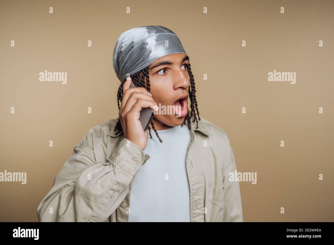 Young man with surprised expression talking on phone Stock Photo