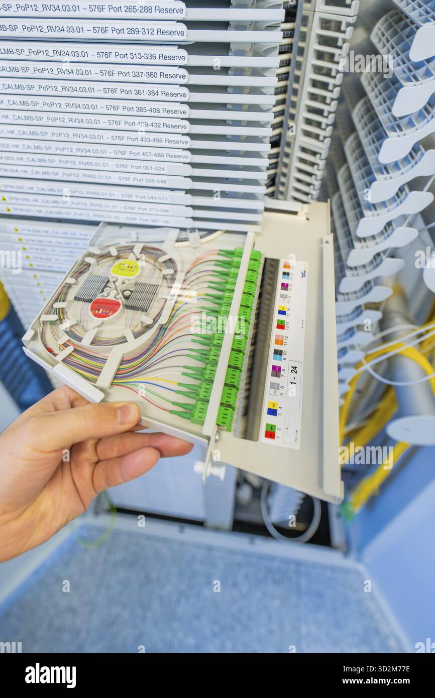 Hand holding a fiber optic cabling module in a technical environment, optical fiber Stock Photo