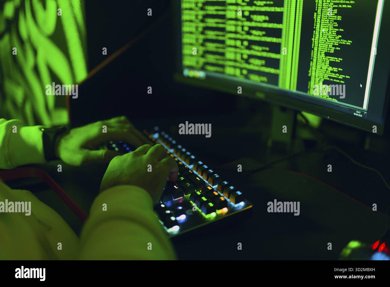 Hacker in hoodie working hacks code site on personal computer. War and cyber attack spy concept Stock Photo
