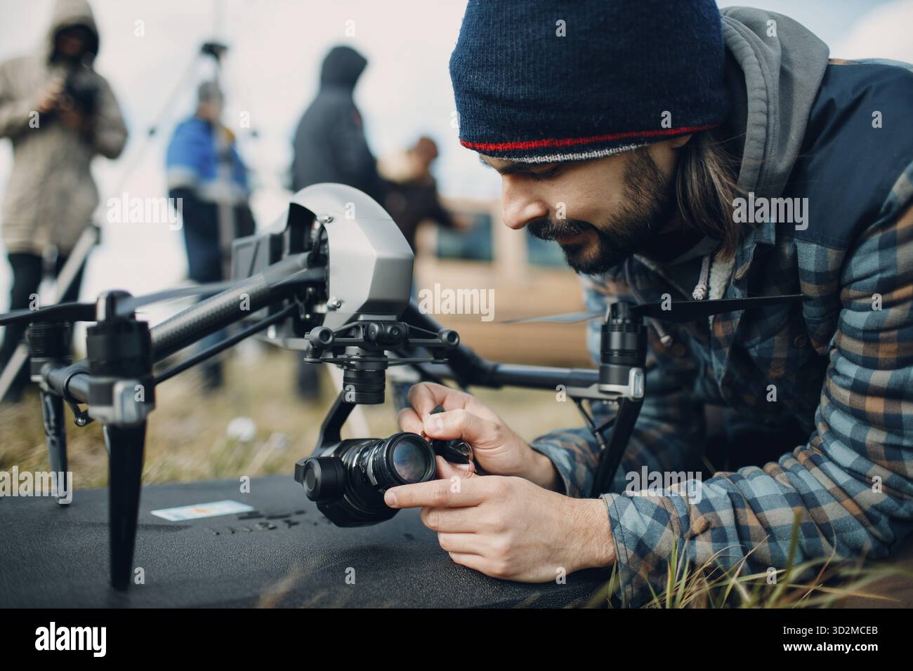 Man pilot checking quadcopter drone camera before aerial flight and filming Stock Photo