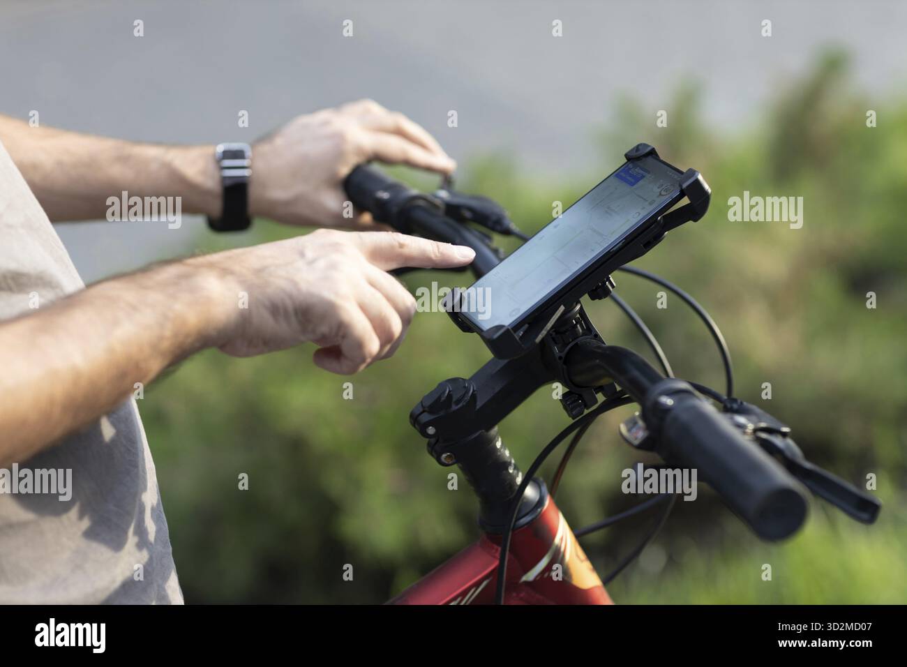 Man planning route pointing finger touch screen GPS navigation application in mobile phone on his bicycle bike Stock Photo