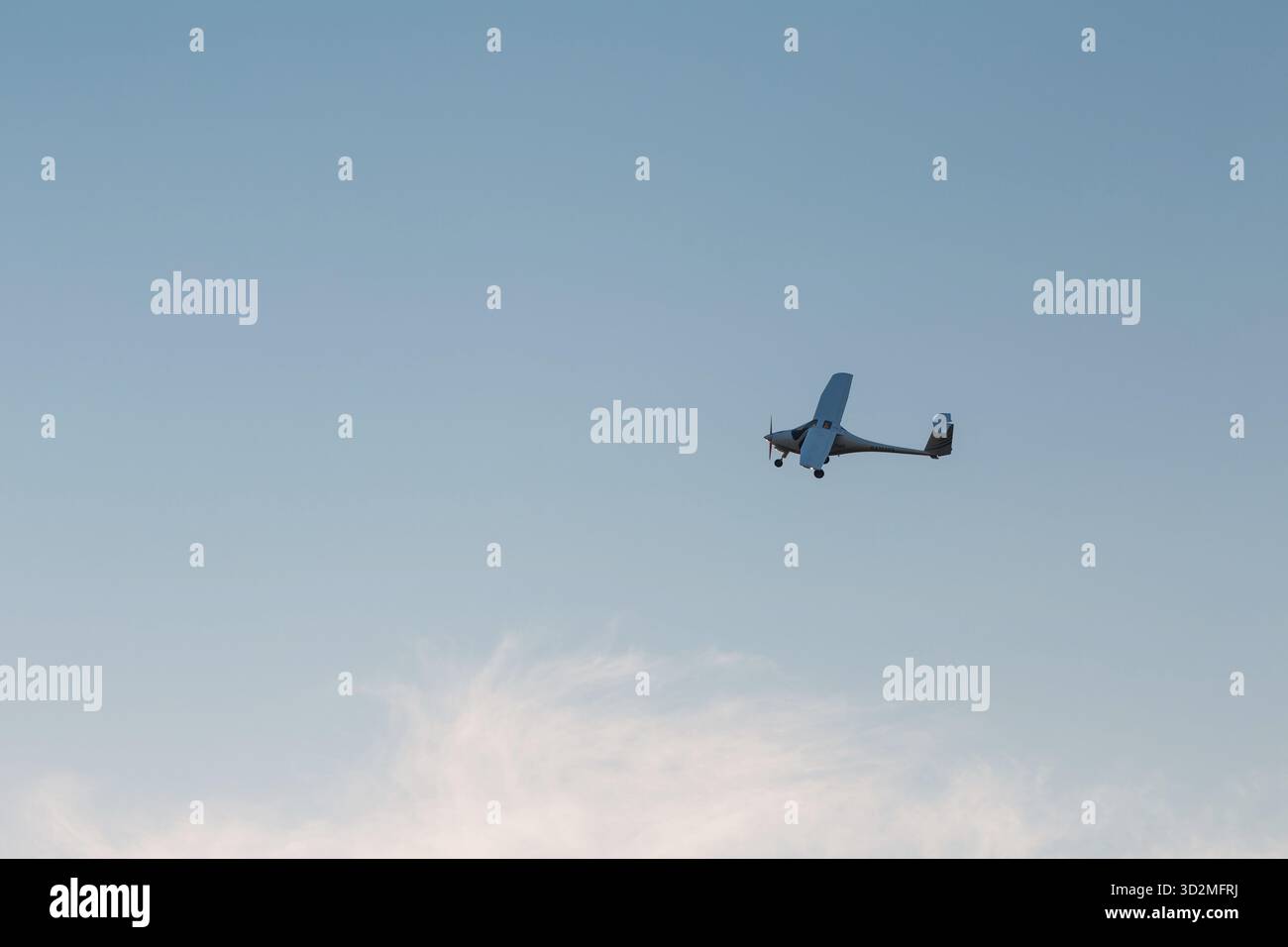 Small single engine airplane flying against sunset sky Stock Photo