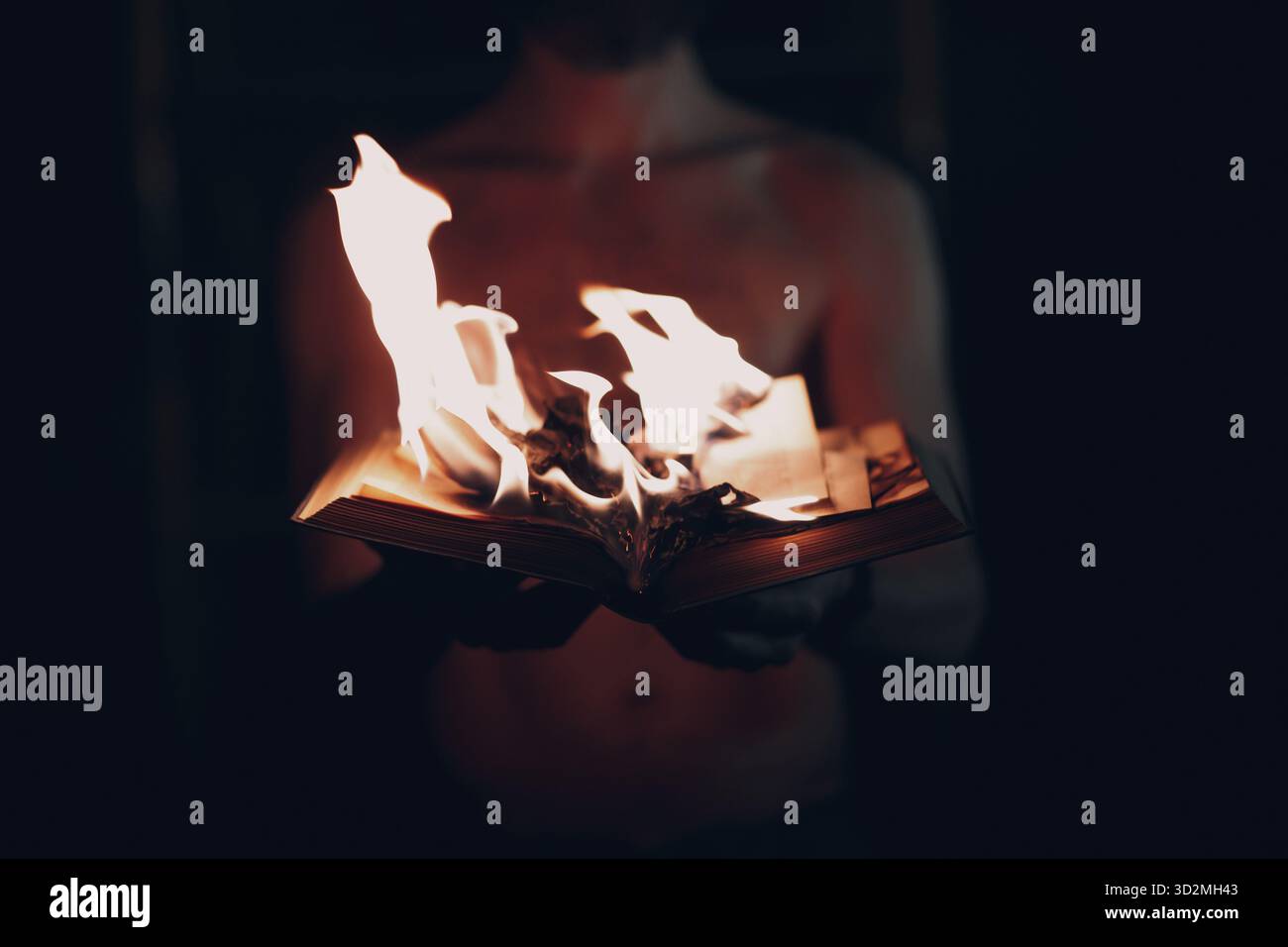 Man hold burning book in his hands Stock Photo