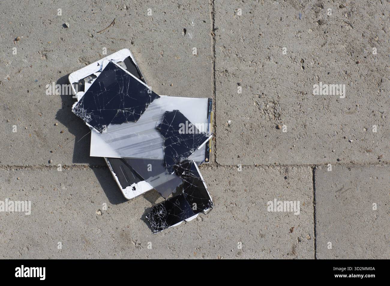 Broken screen mobile phone lies on ground Stock Photo