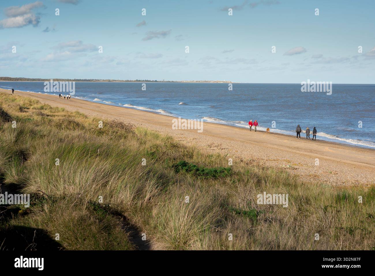 Suffolk beach walking, view of people walking on the beach at Dunwich in Suffolk, England, UK Stock Photo