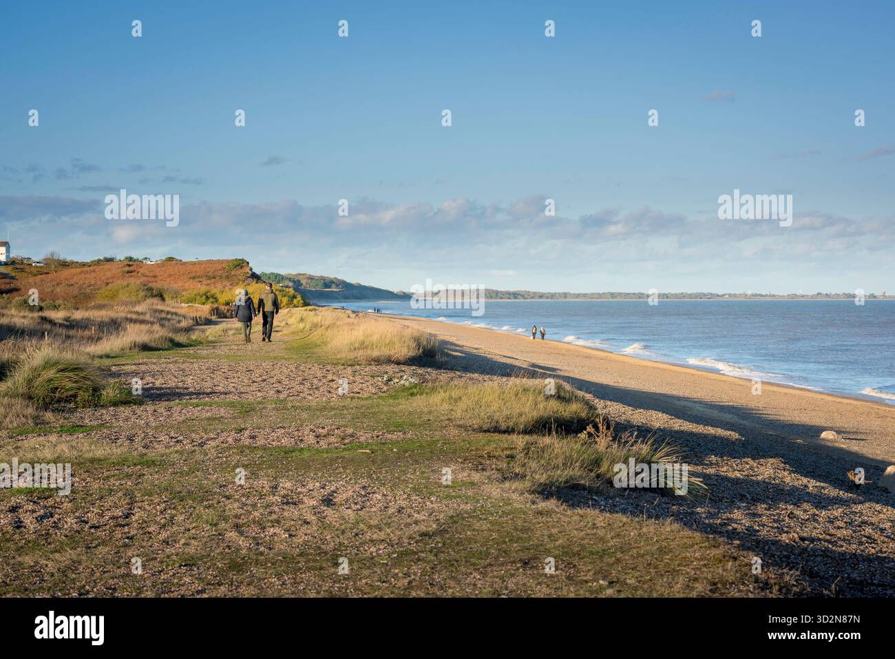 Couple beach UK, rear view of two young people walking together beside the beach at Dunwich in Suffolk, England, UK. Stock Photo