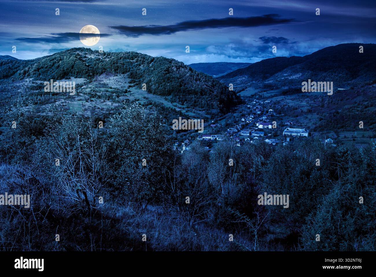 autumn landscape in mountains at night. beautiful view of countryside. colorful alps in the background. cloudy sky. picturesque rural scenery with vil Stock Photo