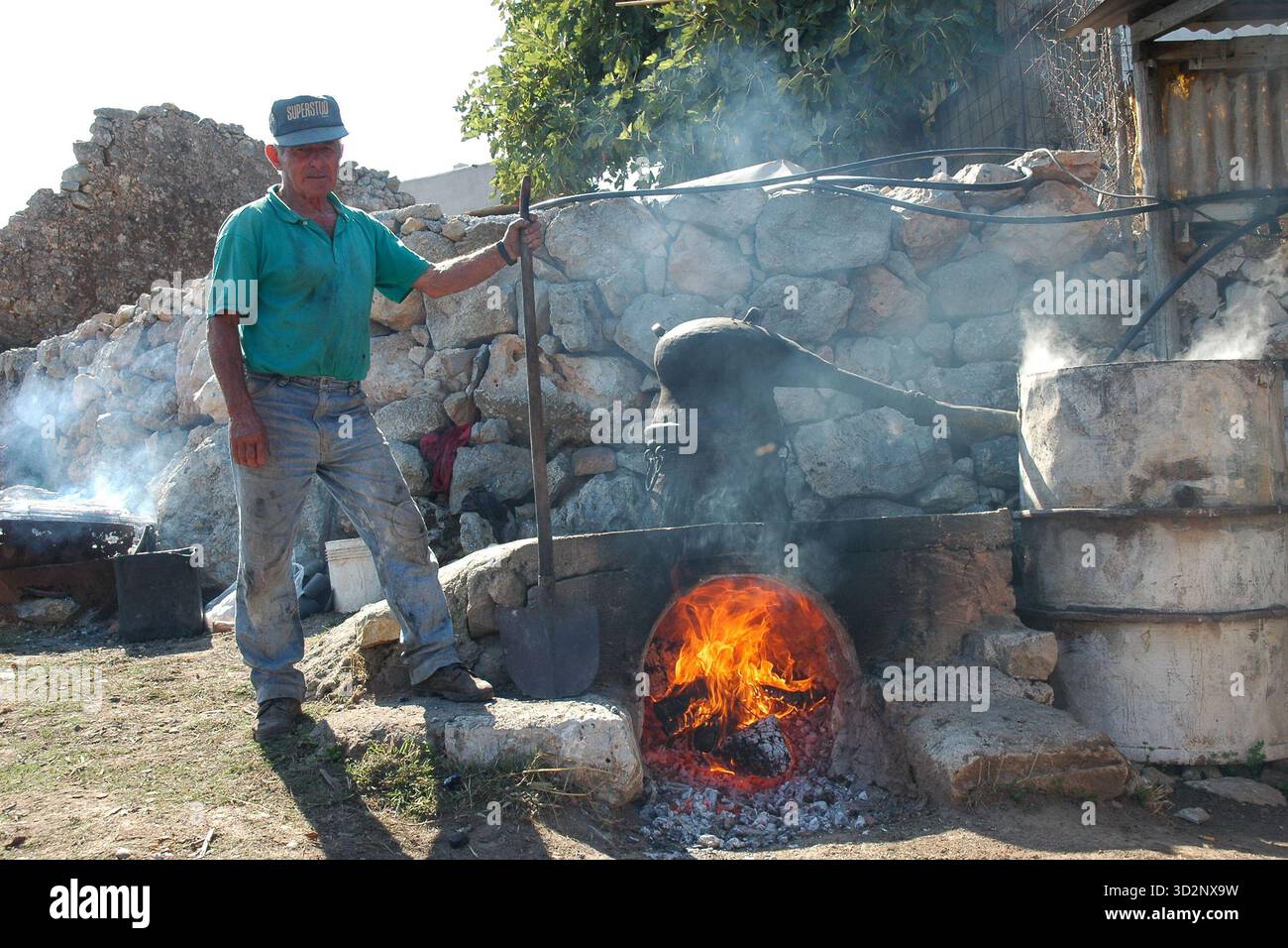 Traditional raki distillation: Man beside cauldron Stock Photo