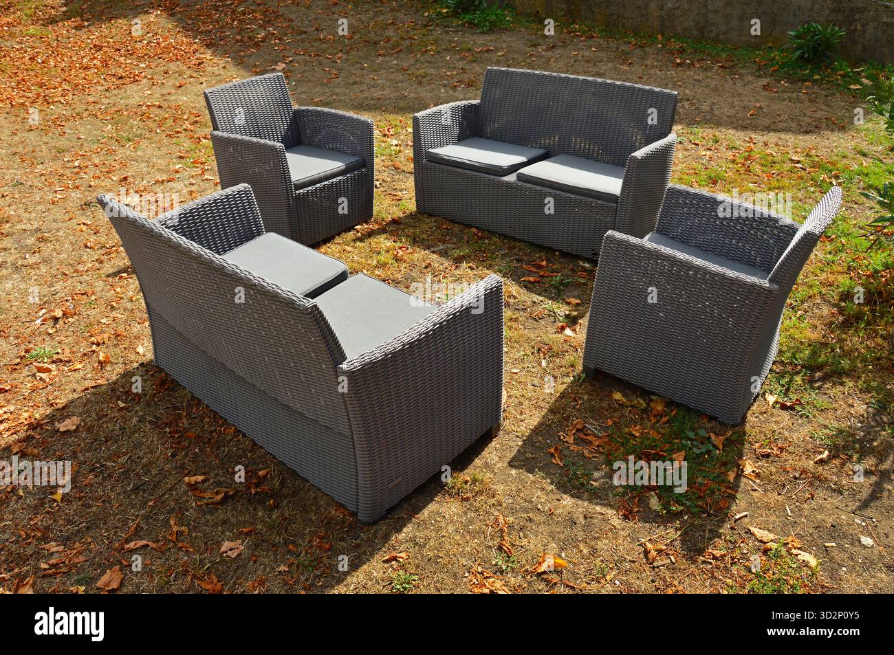 Two chairs and two plastic sofas on the lawn Stock Photo