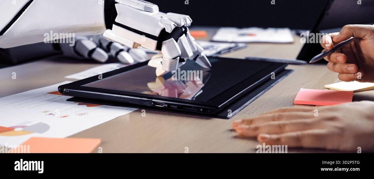 A futuristic robot hand interacts with a digital tablet on a sleek modern workspace, surrounded by colorful sticky notes and design documents, highlig Stock Photo