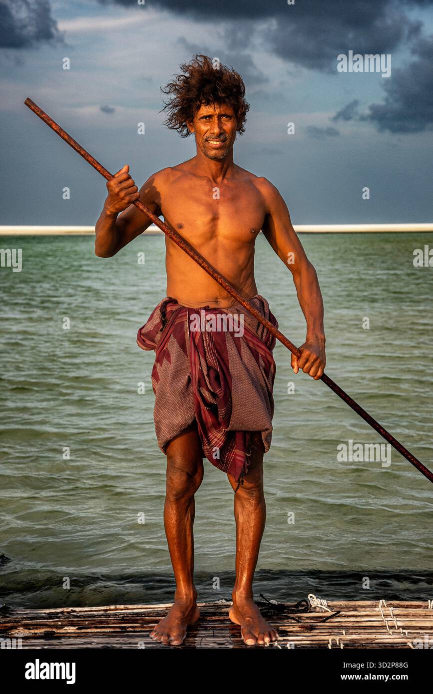 A cave man stands proudly on a raft in Detwah lagoon, Socotra ...