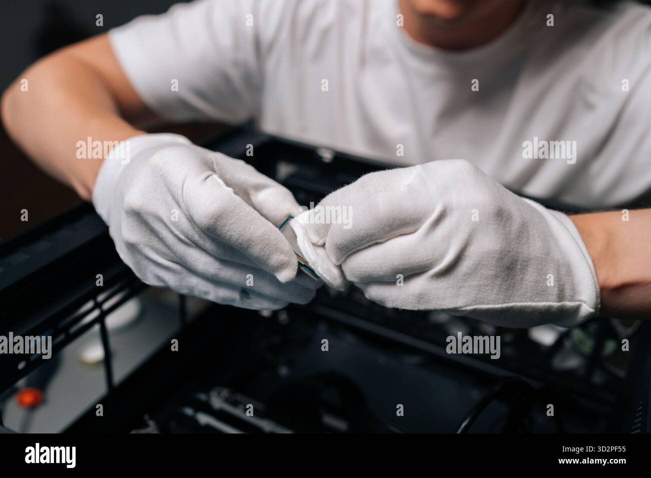 Close-up hands of technician male cleaning computer processor with white cloth, preparing for installation in computer case, ensuring optimal Stock Photo
