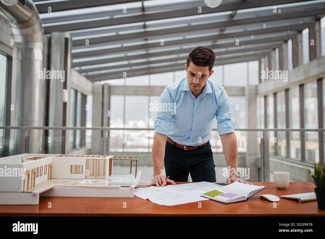 Young businessman, engineer working in office, working on plan or technical document. Stock Photo